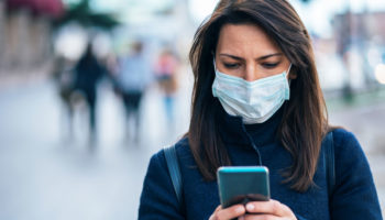 Women using cell phone while wearing mask for Privacy Principles Blog Post