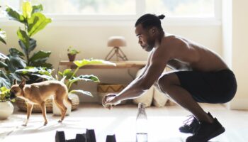 black dog owner squatting at hom