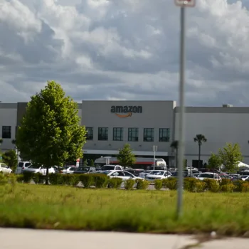 Entrepôt Amazon sous un ciel nuageux.