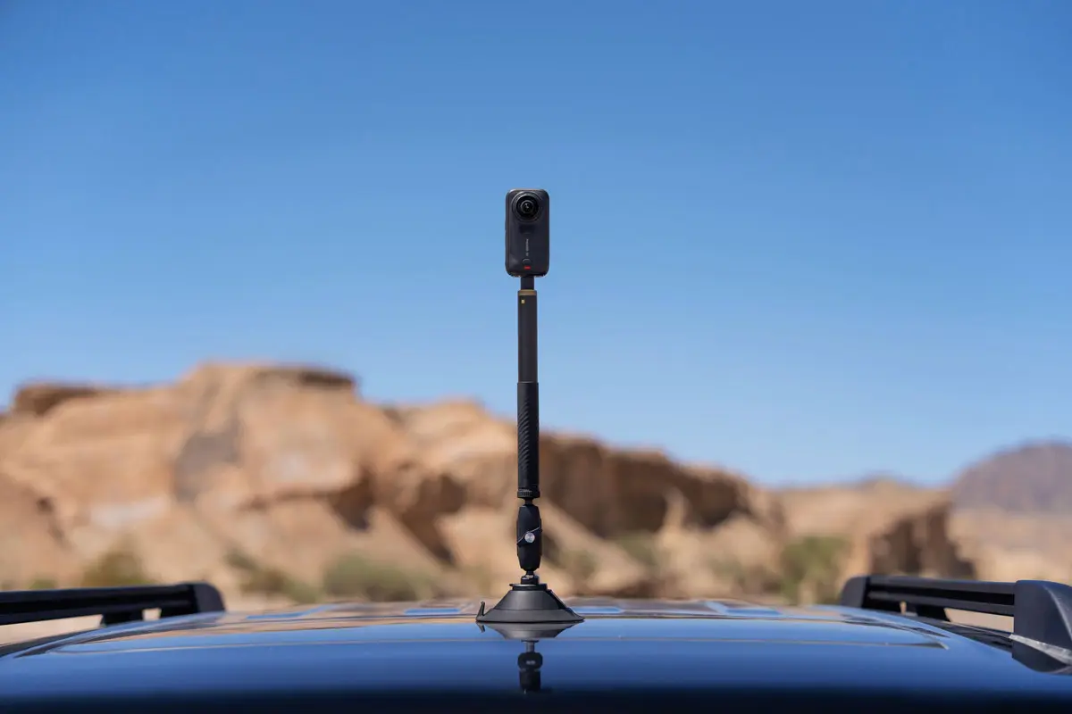 Insta360 X6 camera attached to a suction cup car mount in a desert landscape
